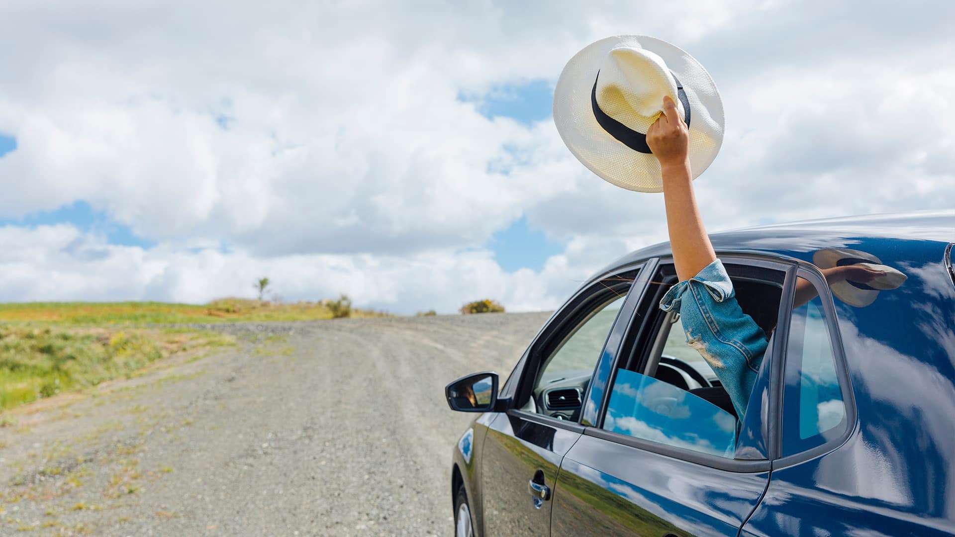 Car on a scenic summer road trip, showcasing well-maintained features with AlloyGator and Rimblades.